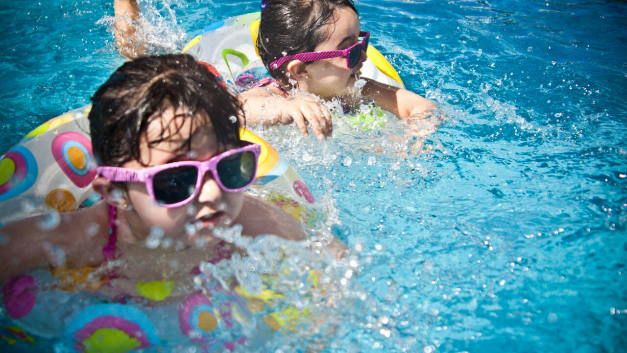 Kids swimming with floaties.
