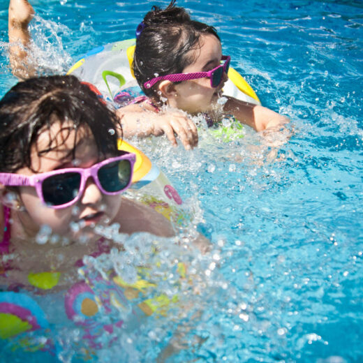 Kids swimming with floaties.