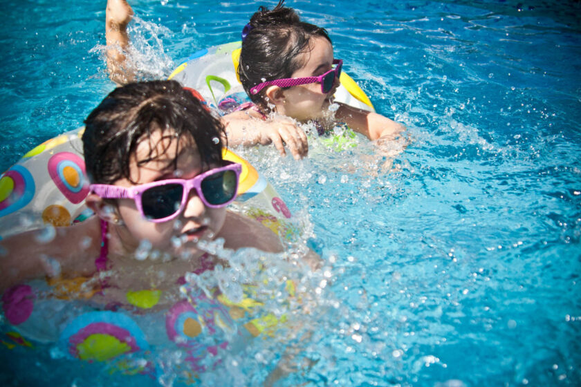 Kids swimming with floaties.